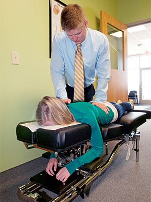 Chiropractor Coon Rapids MN Dillon Sletten Adjusting Patient On Table
